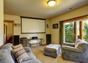Luxury home theater in cabin style home with carpet